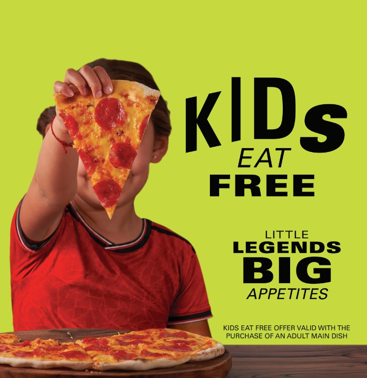 Kids eat free - a child holding up a slice of pepperoni pizza
